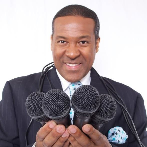 Kevin T. Robertson holding microphones for a keynote booking inquiry